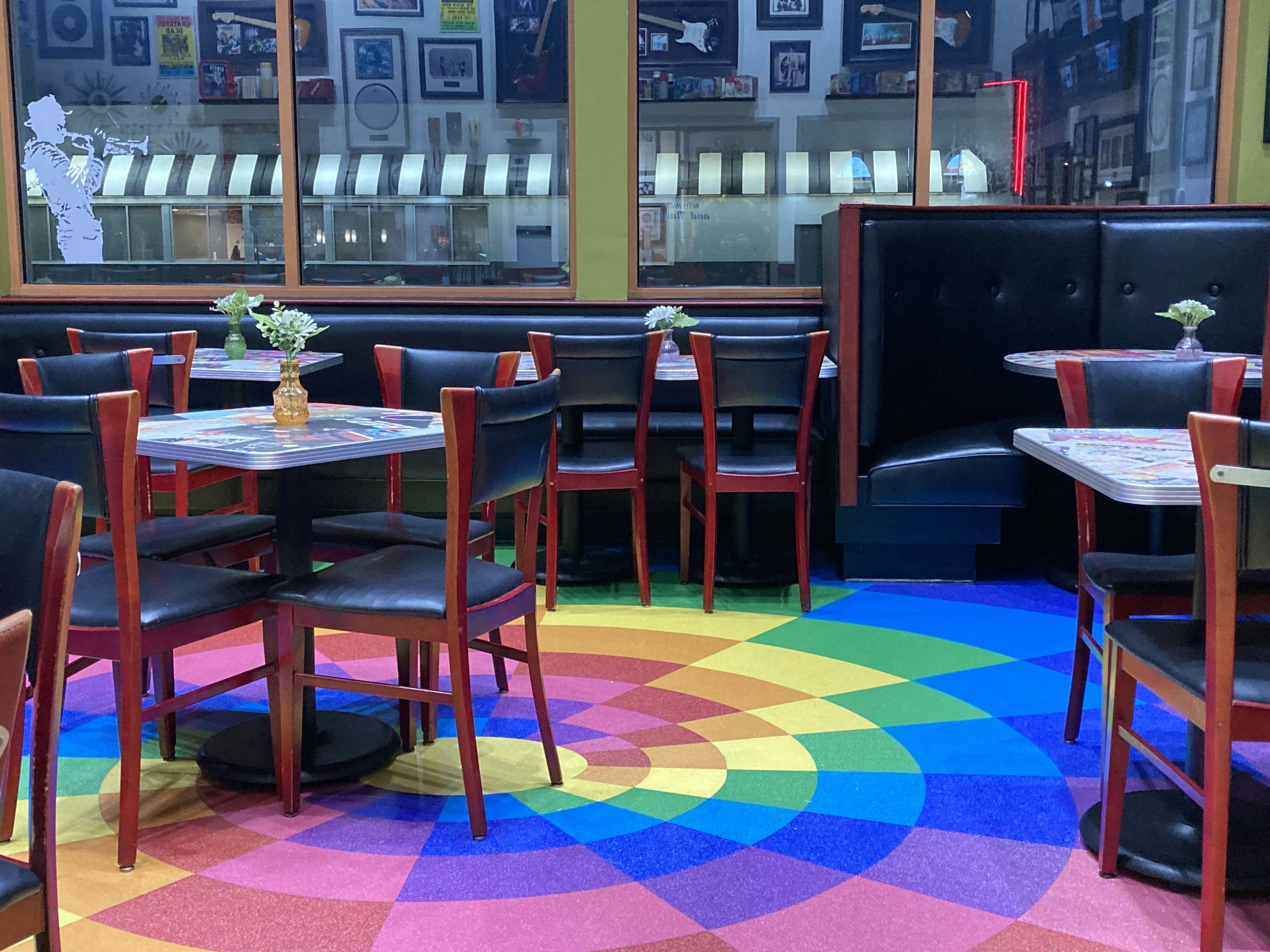 Upscale restaurant interior with rainbow flag decoration and diverse diners