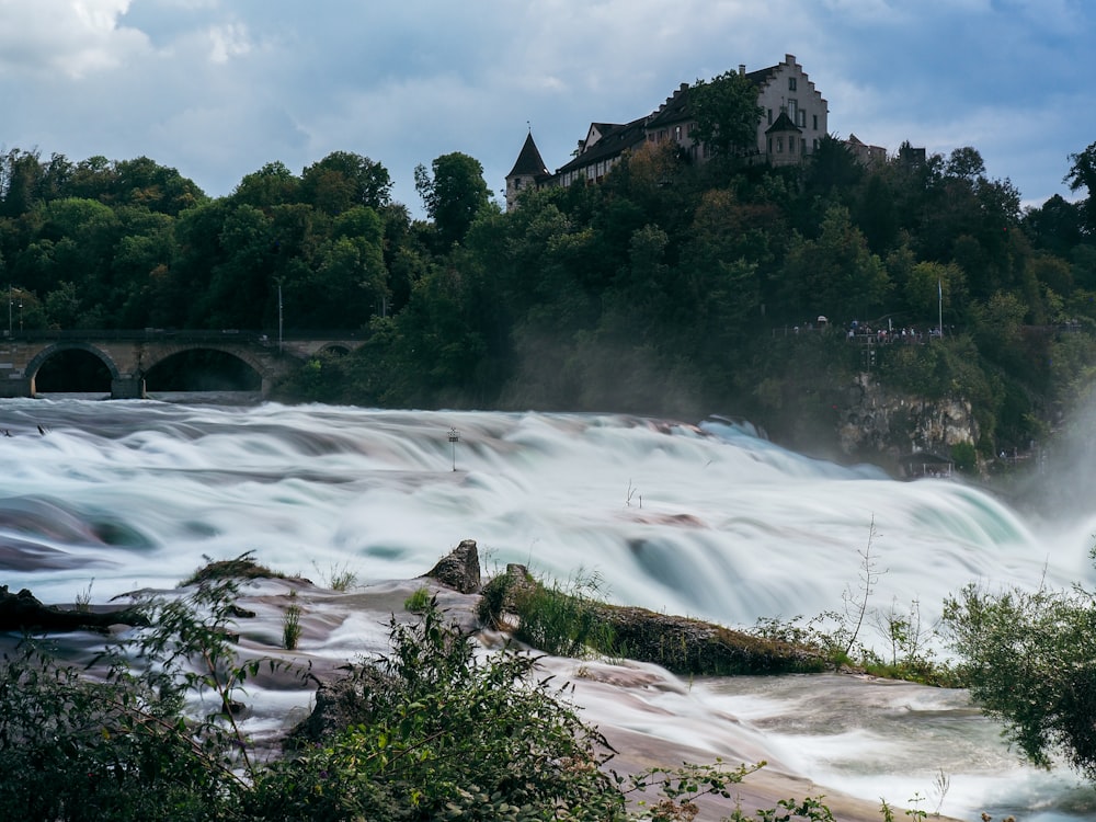 a large waterfall with a castle in the background