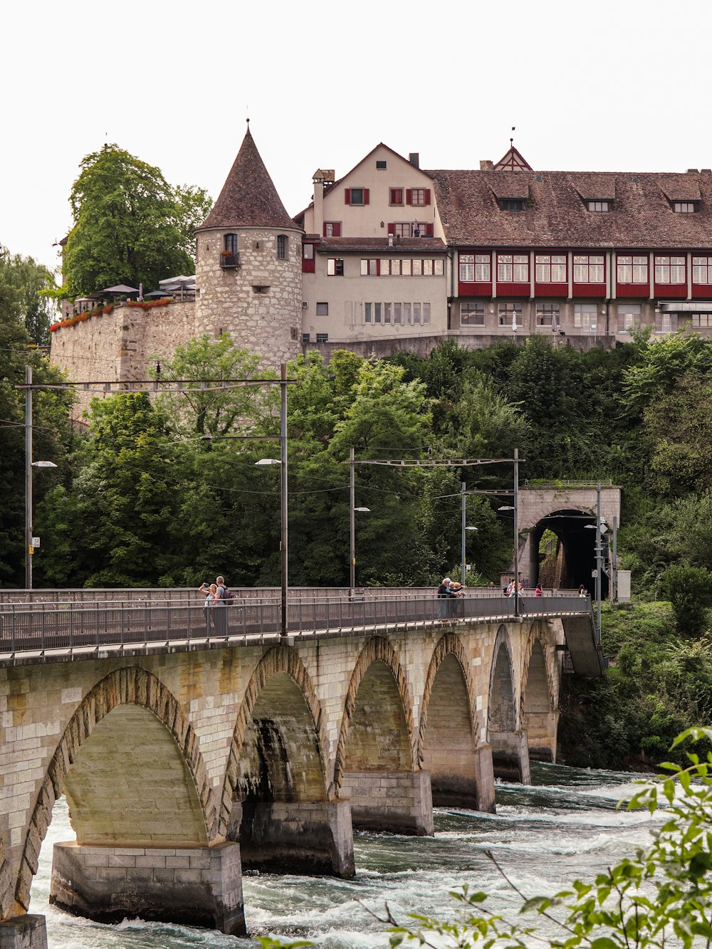 a bridge over a river with a building in the background