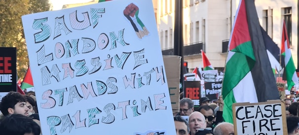 A peaceful protest scene with people carrying banners in a city.