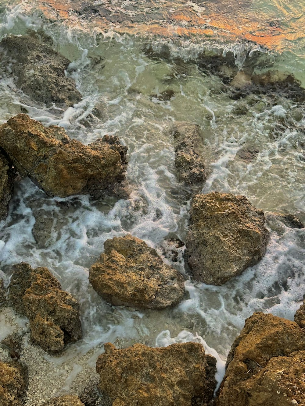 a view of the ocean with rocks in the foreground