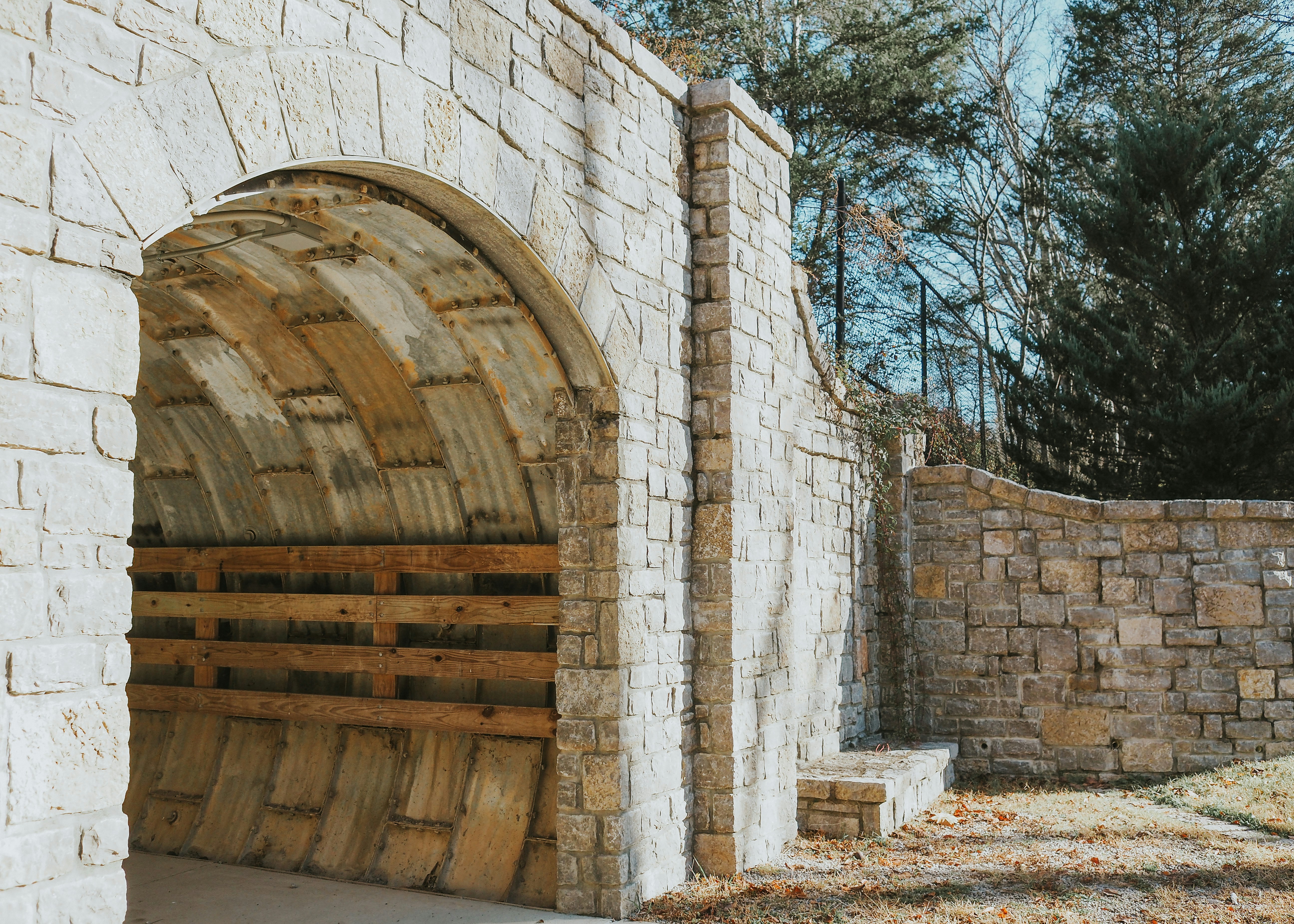 a stone building with a wooden door and a brick wall