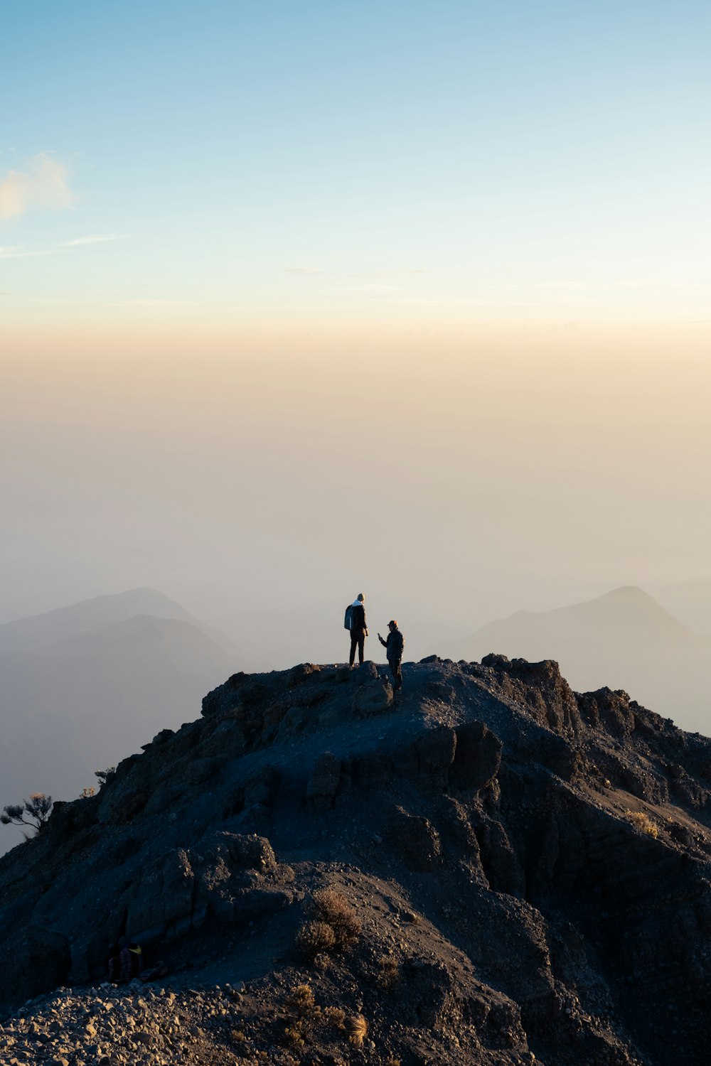 a couple of people standing on top of a mountain