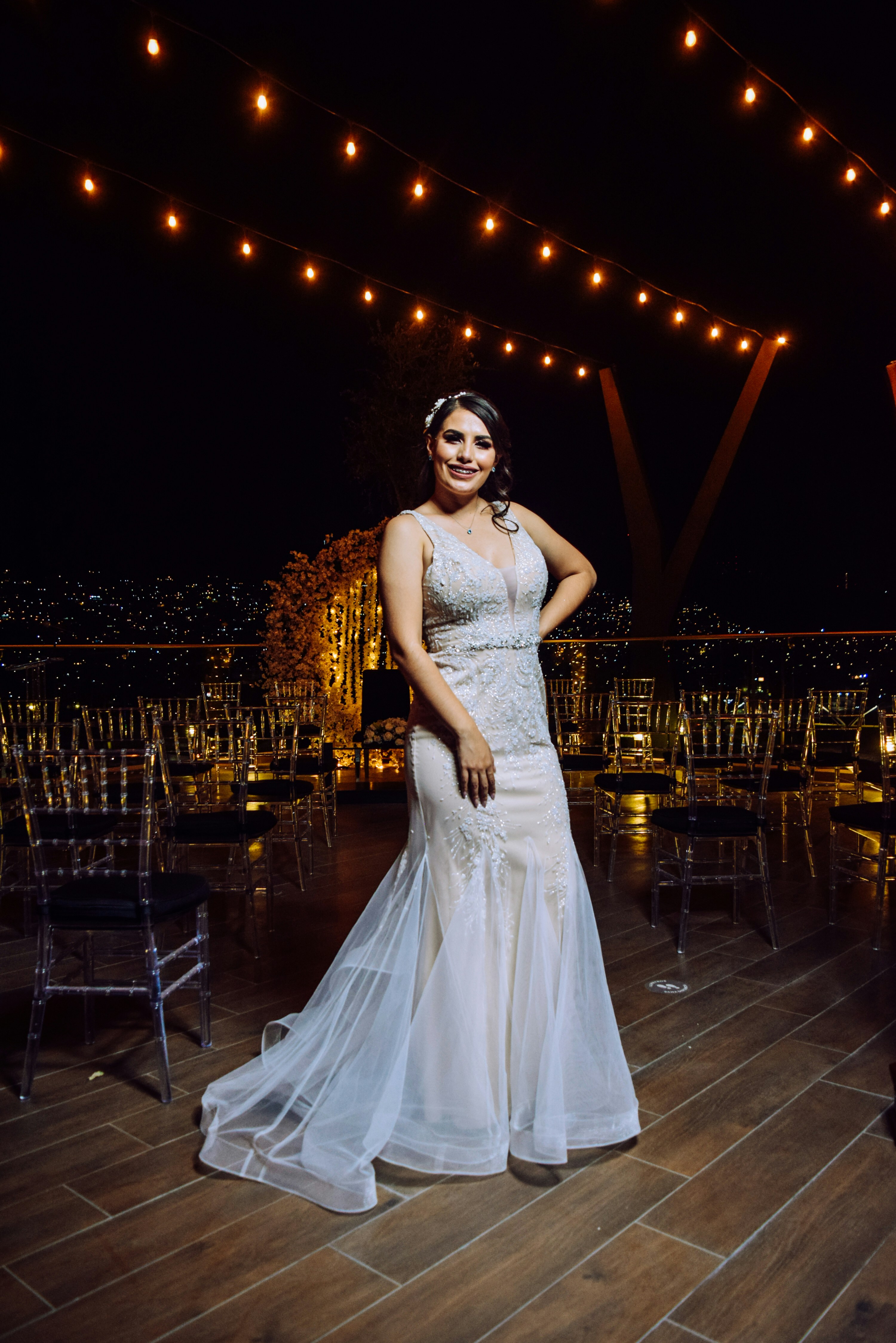 a woman in a white dress standing on a wooden floor