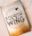 A book cover featuring a gold and white design with the title 'Fourth Wing' prominently displayed. Surrounding the title is an intricate pattern of clouds and a flying dragon. The cover highlights the author's name, Rebecca Yarros, and includes a quote praising the book as a highly addictive fantasy.