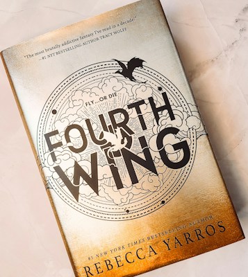 A book cover featuring a gold and white design with the title 'Fourth Wing' prominently displayed. Surrounding the title is an intricate pattern of clouds and a flying dragon. The cover highlights the author's name, Rebecca Yarros, and includes a quote praising the book as a highly addictive fantasy.