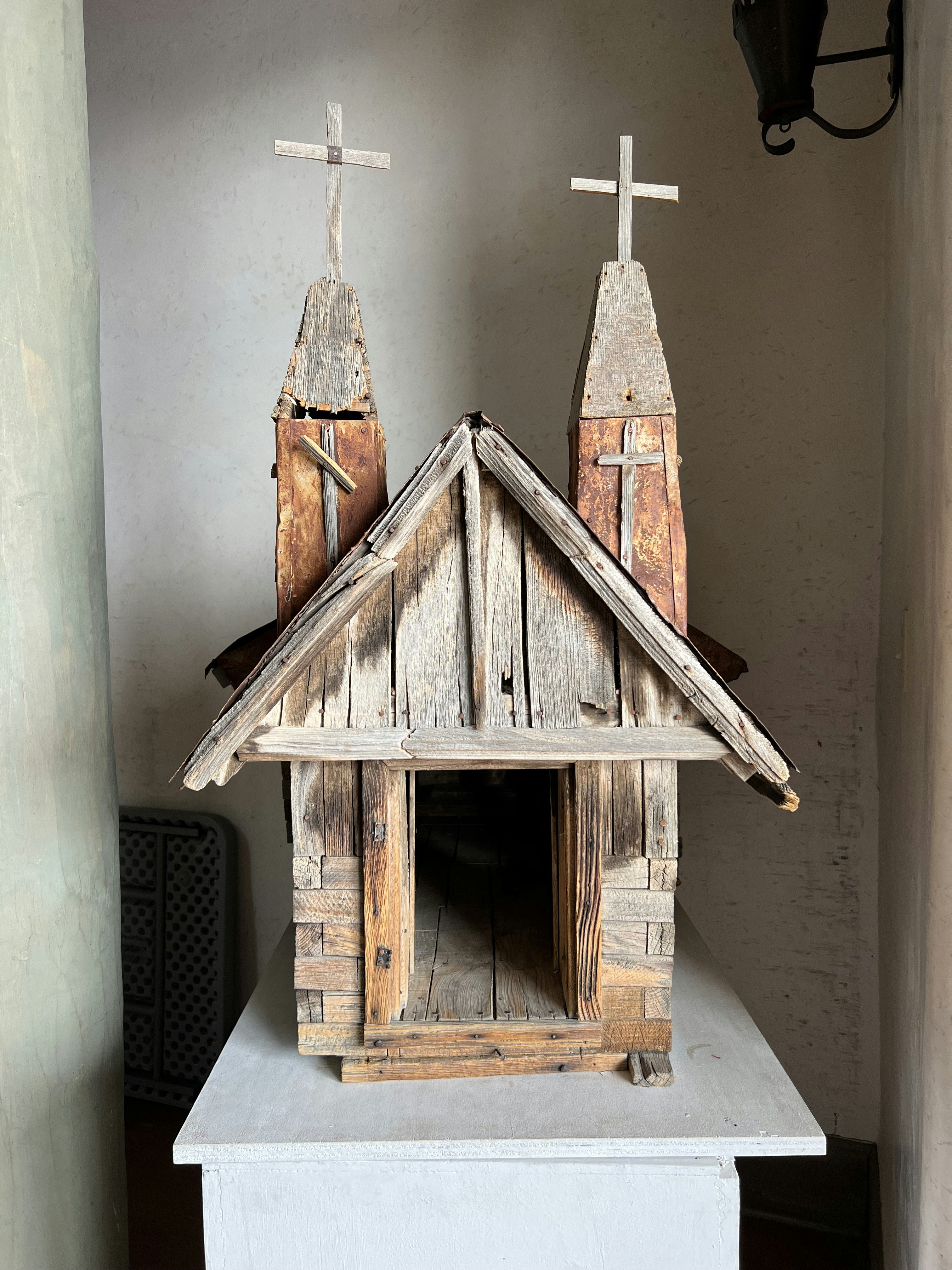 a small wooden church with two crosses on top of it