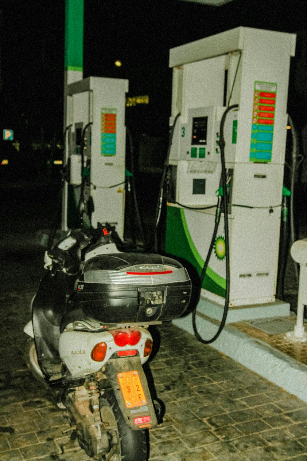 uma motocicleta estacionada ao lado de uma bomba de gasolina