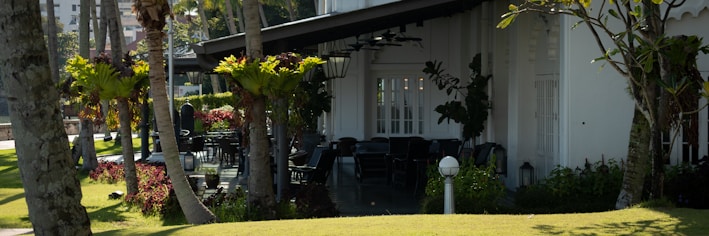 Backyard patio with seating area surrounded by lush greenery.
