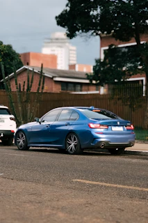 Close-up photo of a sleek blue Toyota sedan parked on a city street.