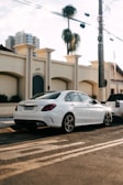 Black luxury sedan parked in front of a modern office building at sunset.
