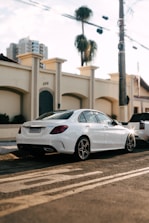 A polished luxury sedan parked near an airport terminal with sunset lighting.