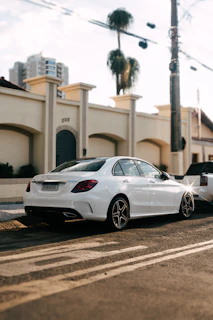 Clean white luxury sedan shining in an open parking lot at sunset