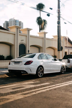 A sleek silver sedan parked on a sunny Cancún street with palm trees in the background