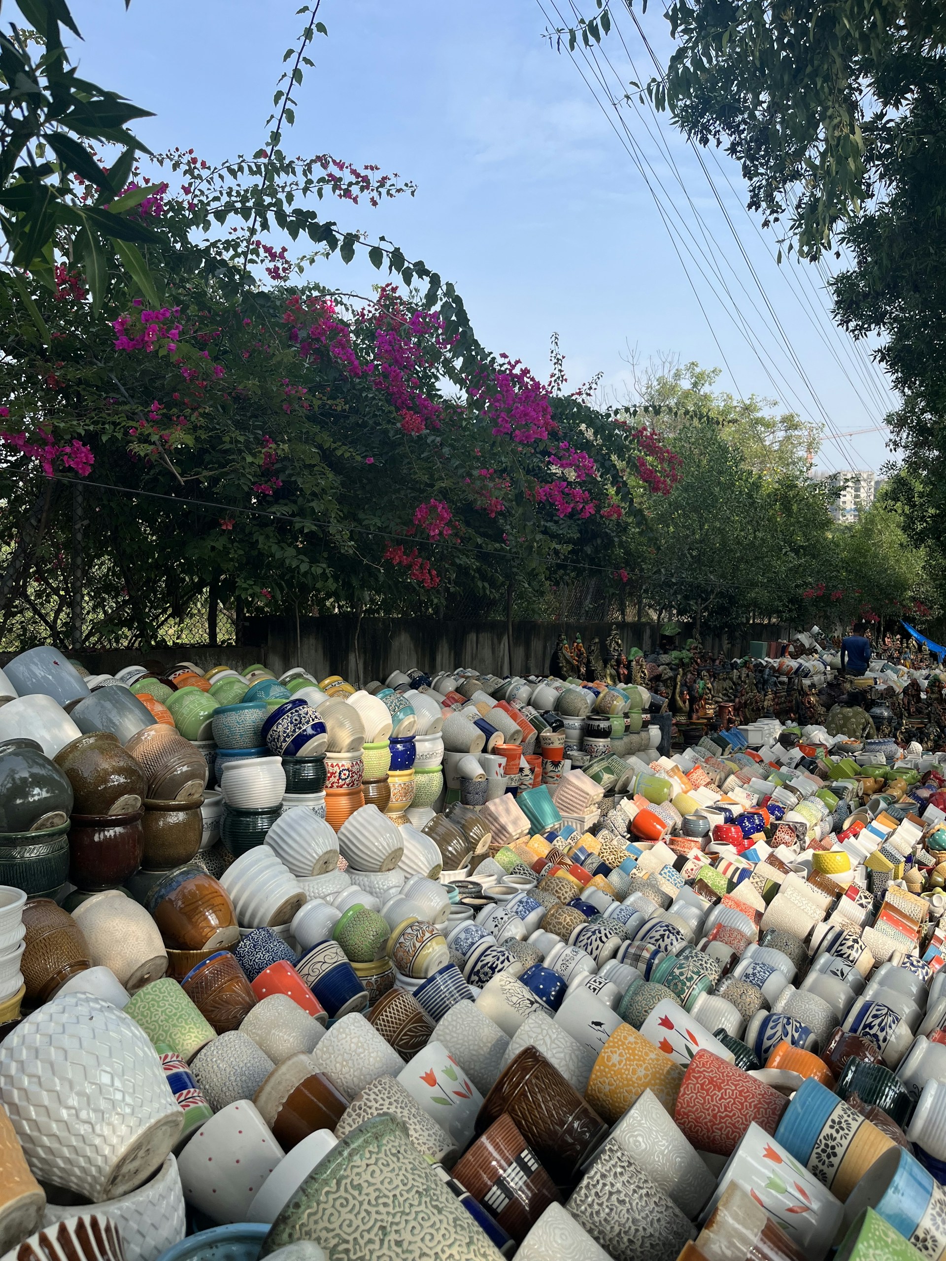 A vibrant outdoor exhibition showcasing diverse ceramic artworks surrounded by visitors in Vinhedo.