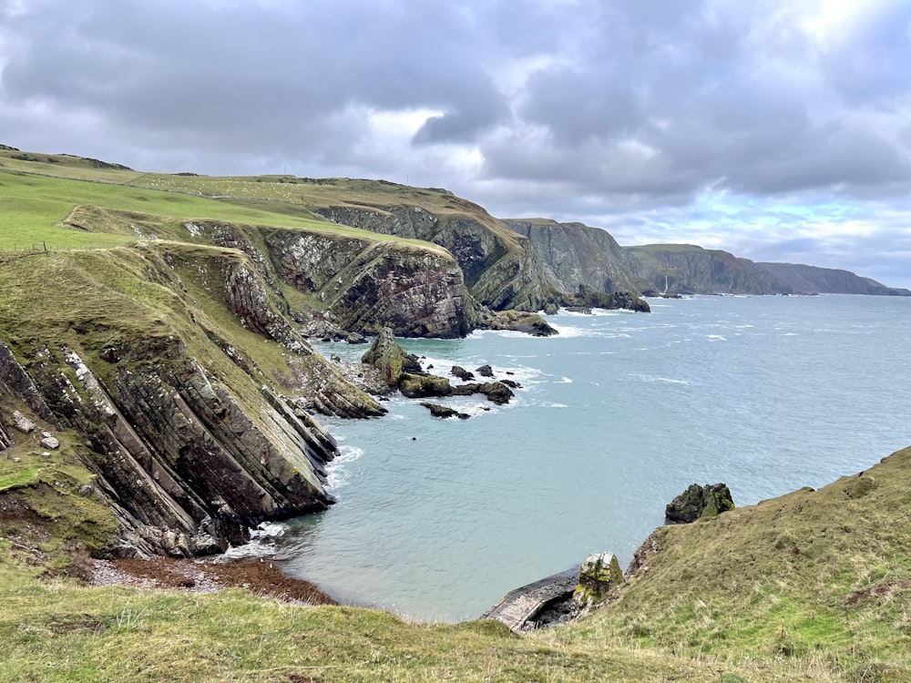 a large body of water surrounded by green hills