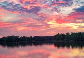 A vibrant sunset over a calm lake reflecting colorful skies.