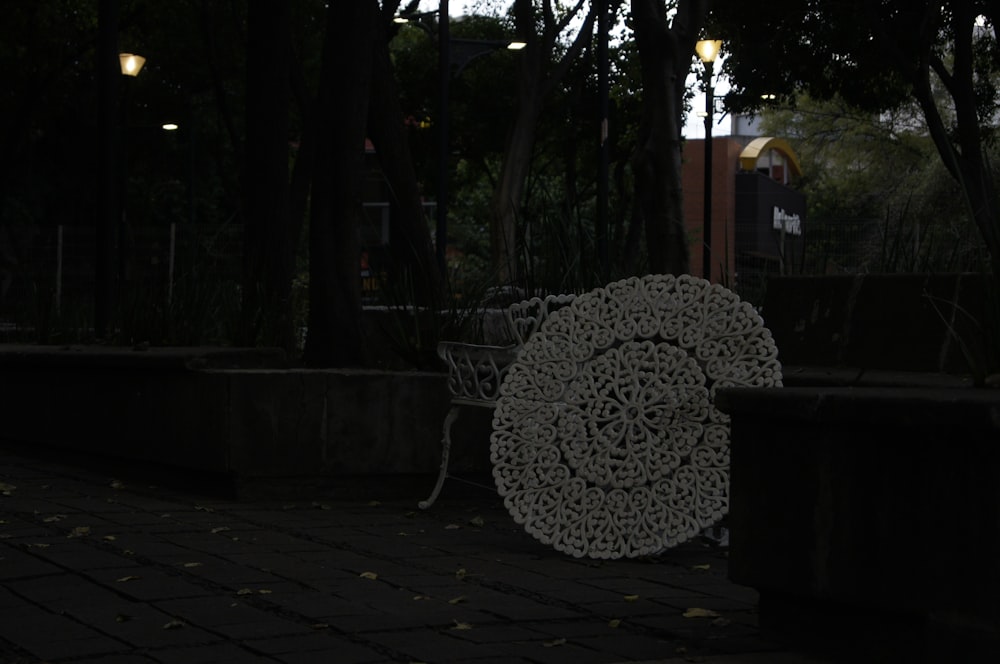 a white sculpture sitting on top of a brick sidewalk