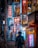 A bustling urban street at night, illuminated by vibrant neon signs in Japanese. The atmosphere is lively with people walking along the sidewalk. Various signs advertise karaoke, restaurants, and shops. The colors and lights create a lively ambiance amidst the dark surroundings.