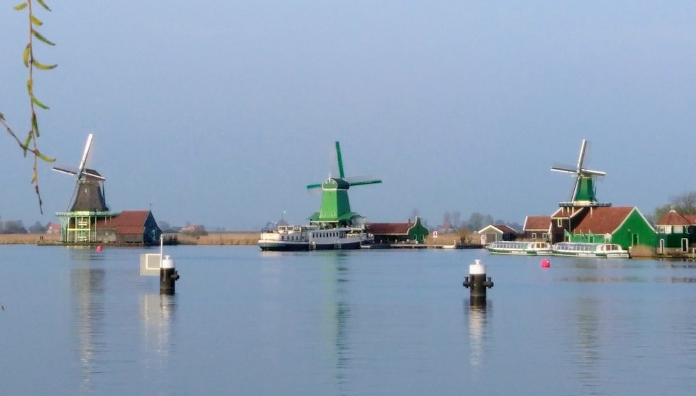 a group of windmills sitting on top of a body of water