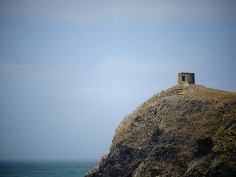 a small tower on top of a cliff by the ocean