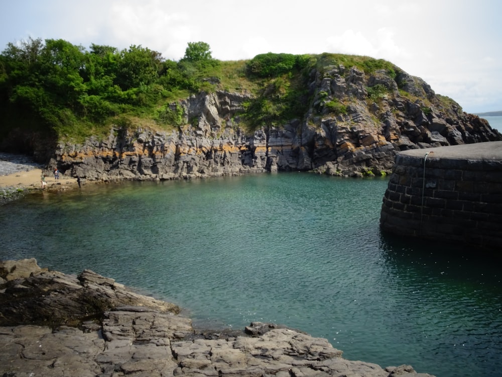 a body of water surrounded by rocks and trees