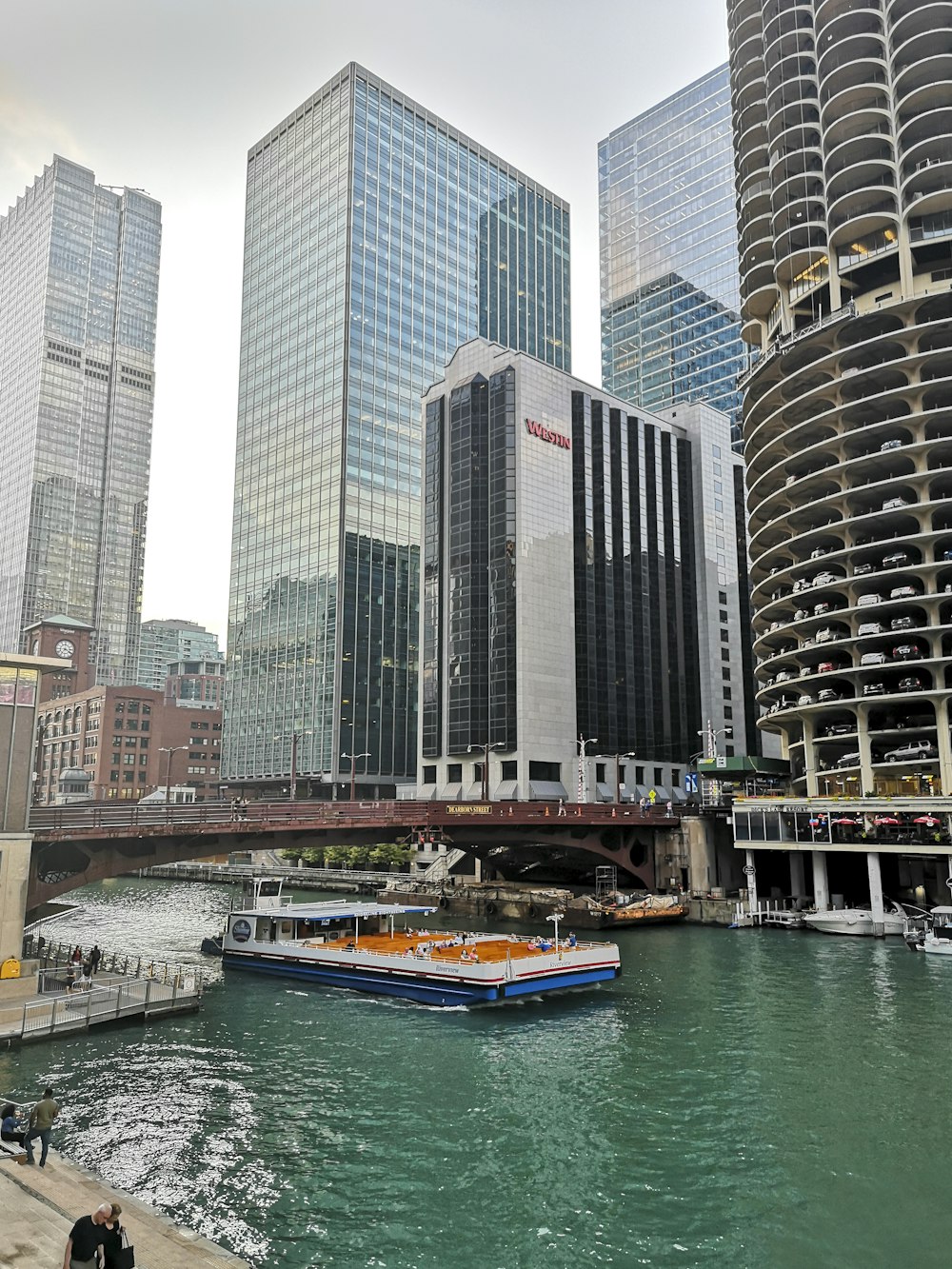 a boat traveling down a river next to tall buildings