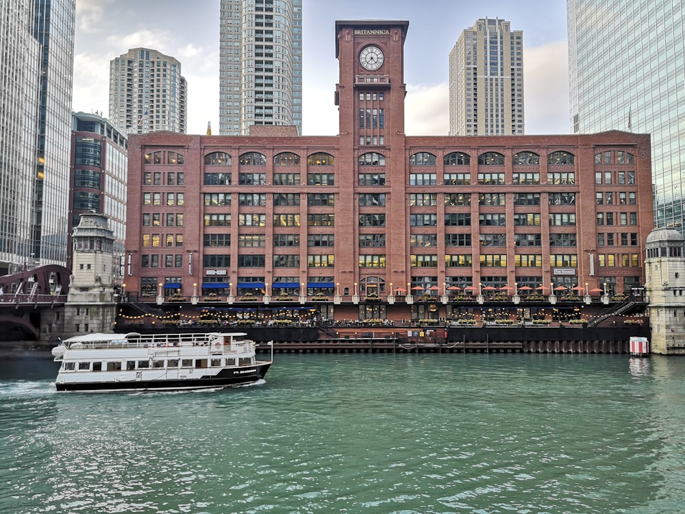 un bateau descendant une rivière en passant devant un grand bâtiment