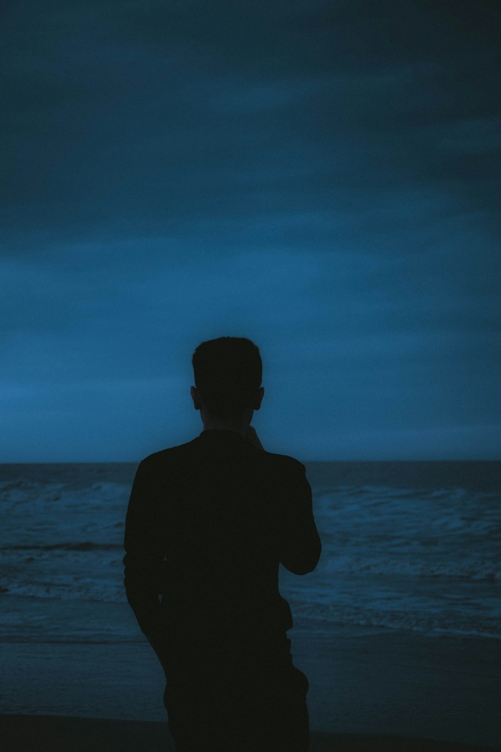 a man standing on a beach next to the ocean