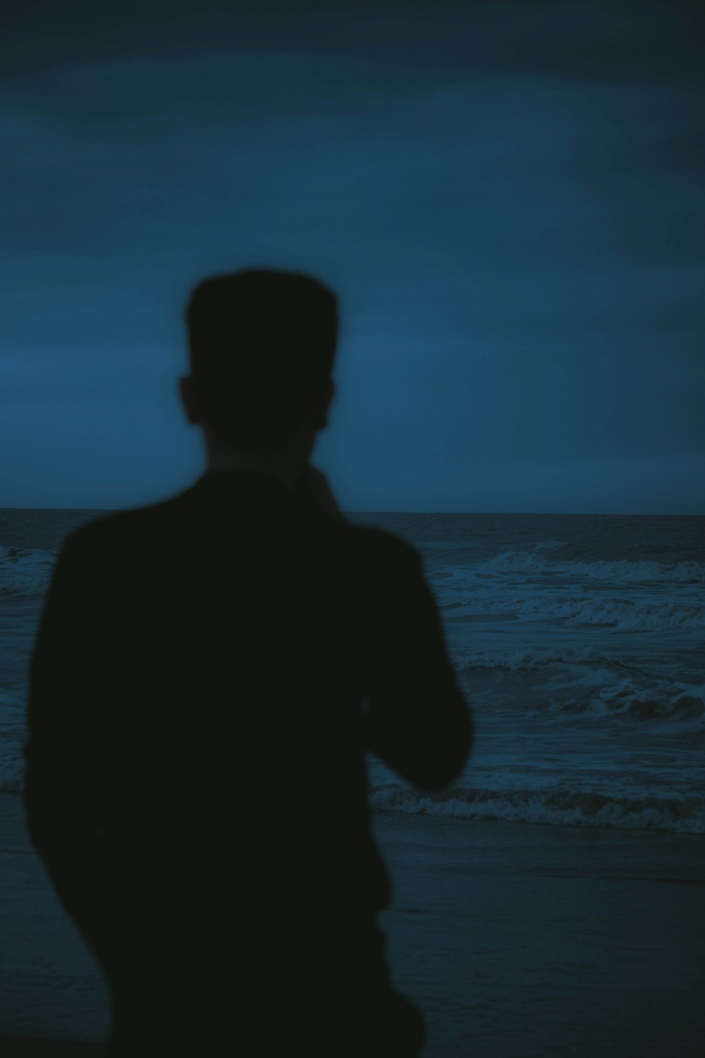 a man standing on a beach next to the ocean