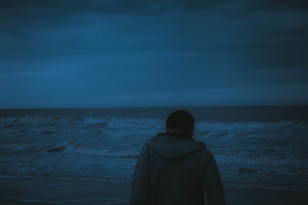 a person standing on a beach at night