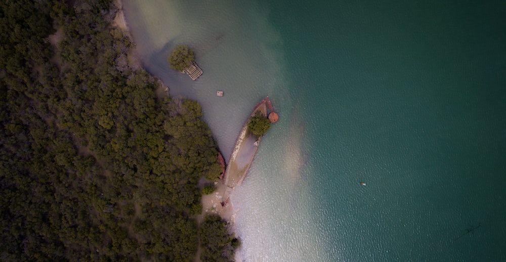 an aerial view of a beach with a boat in the water