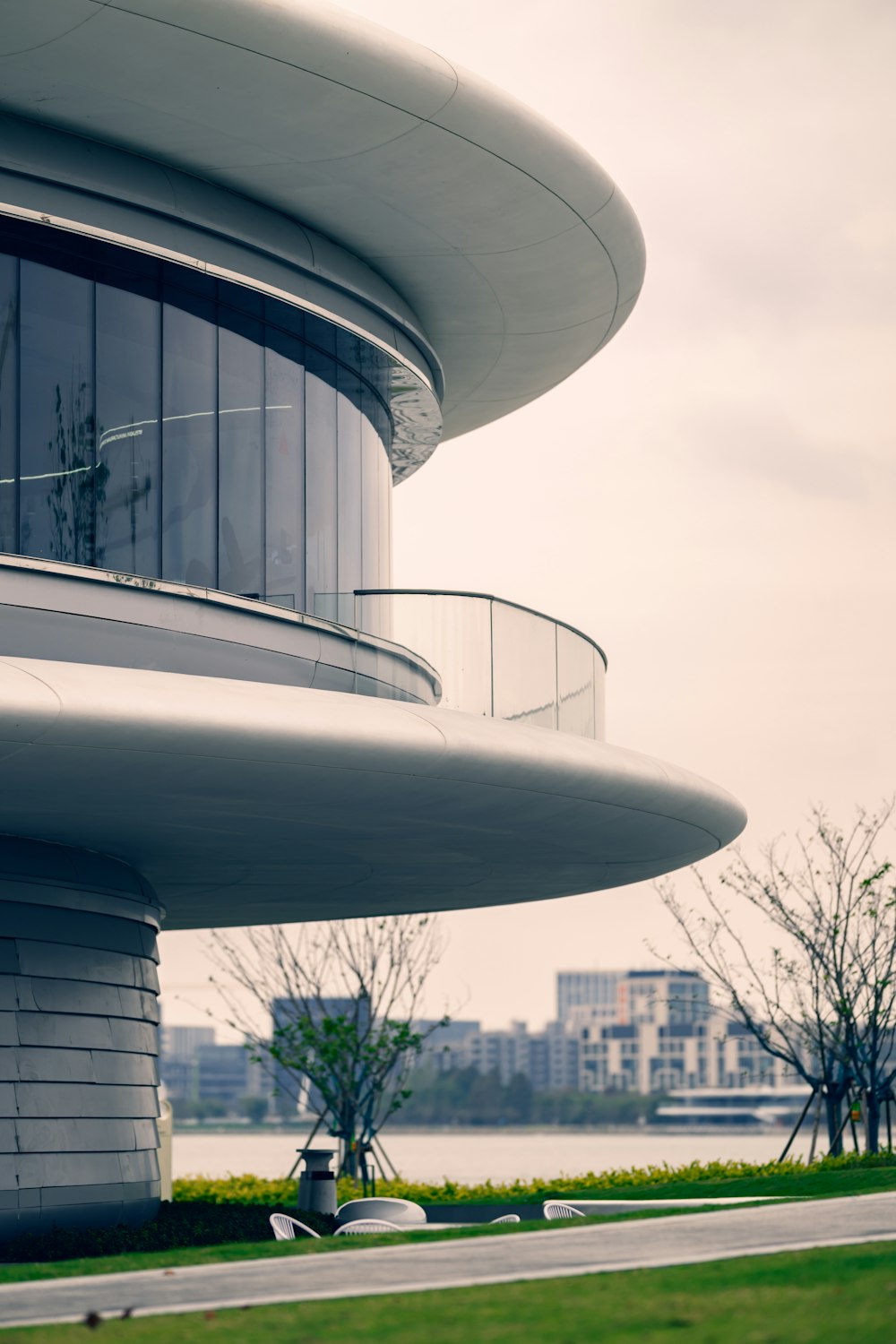 a tall building with a balcony next to a body of water