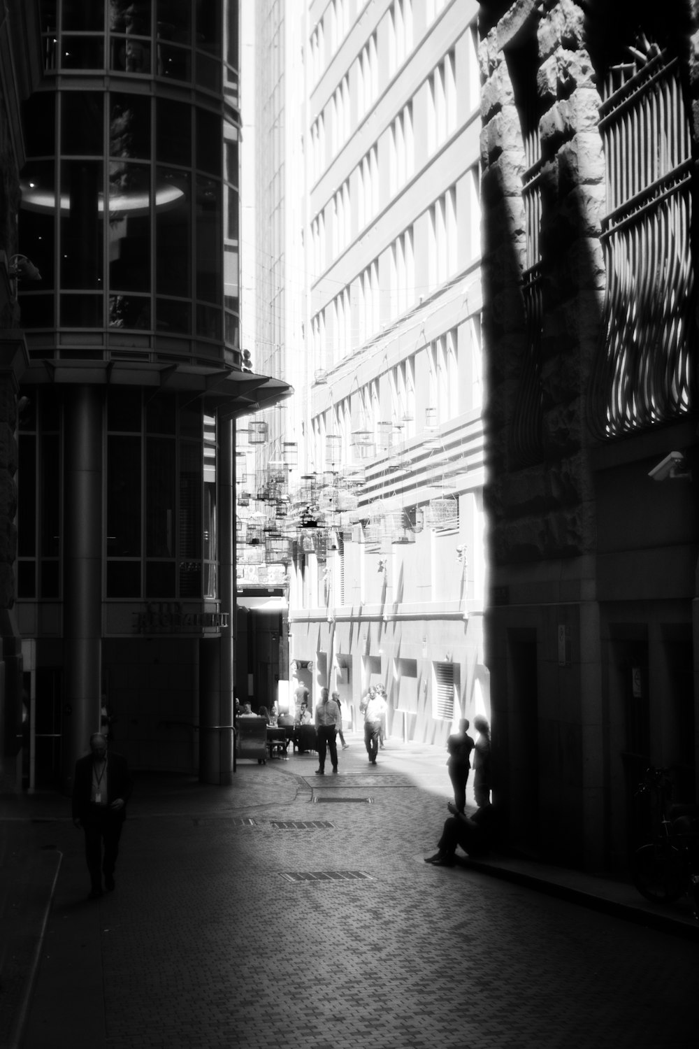 a black and white photo of people walking down a street