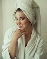 A smiling client wrapped in a plush robe, enjoying a peaceful moment after a rejuvenating treatment.