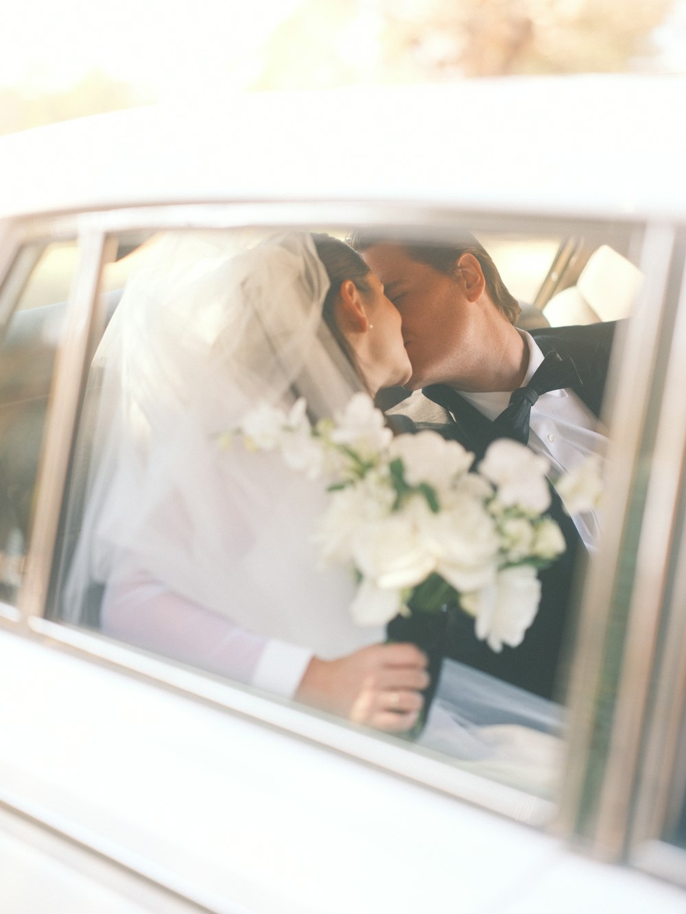 a bride and groom kissing in a limo