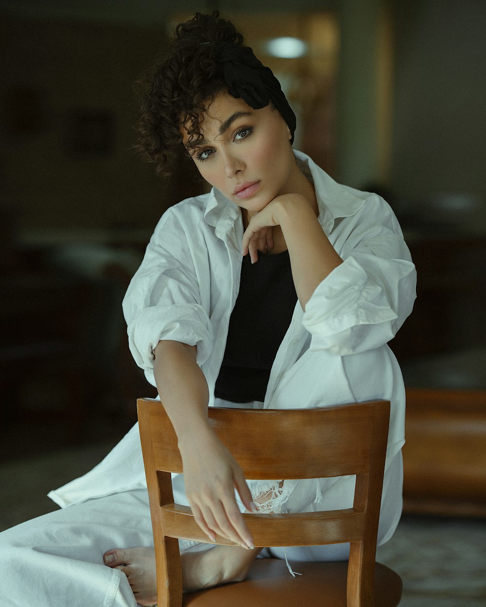 a woman sitting on top of a wooden chair