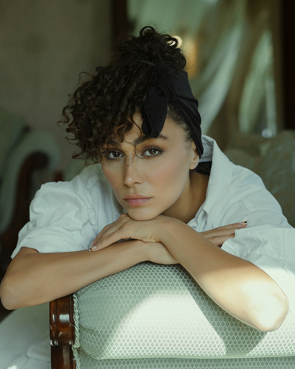 a woman sitting on a chair with her arms crossed