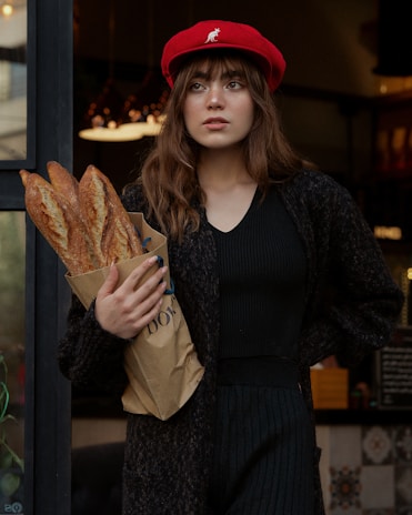 Happy customer holding a paper bag with scbd88 logo outside a simple, cozy bakery setting.