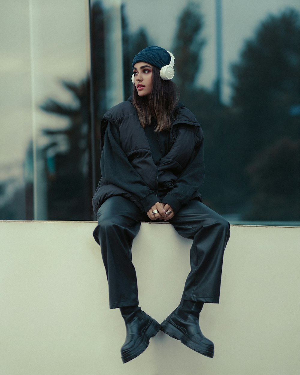 a woman sitting on top of a white wall