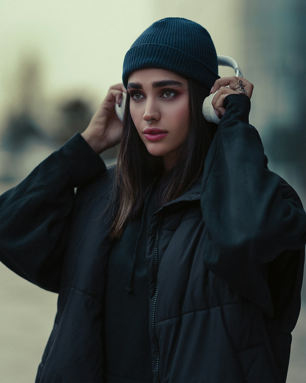 a woman in a black jacket is talking on a cell phone