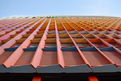 Close-up of colorful sandwich panels being installed on a commercial building facade.