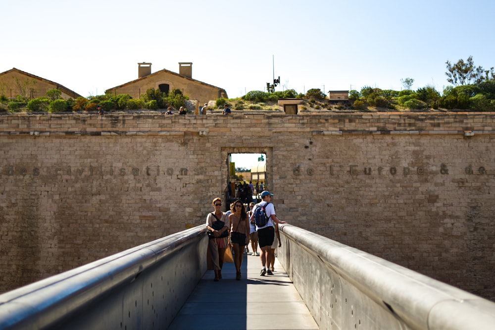 a group of people walking across a bridge