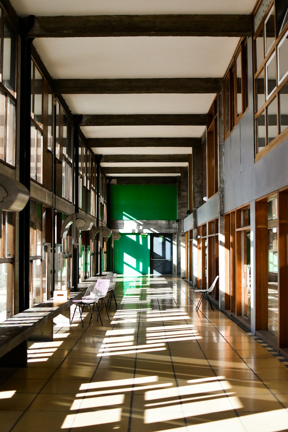 a long hallway with lots of windows and benches