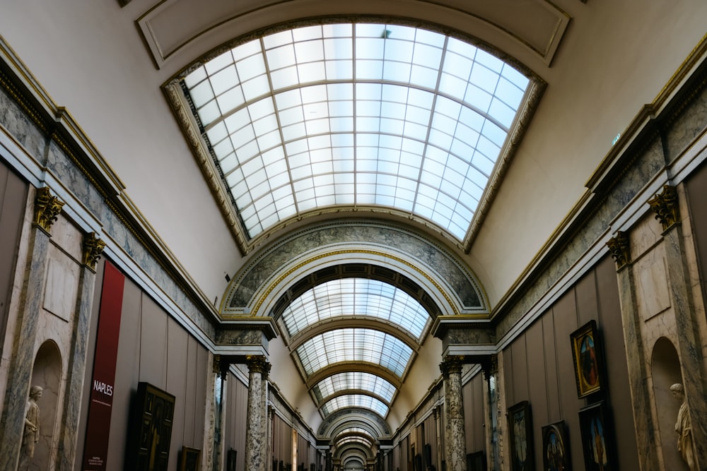 a long hallway with a skylight and paintings on the walls