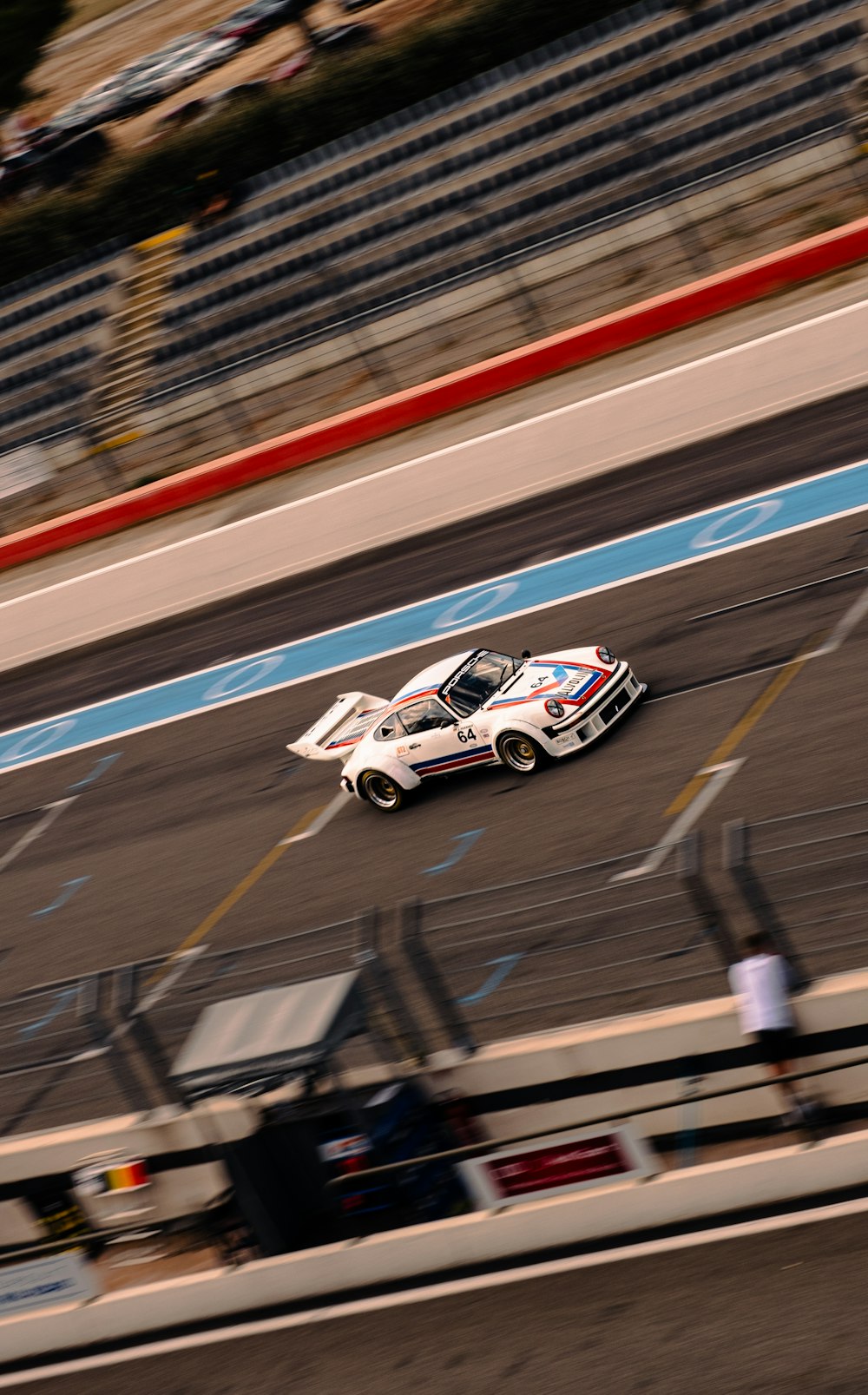 a car driving down a race track with people watching