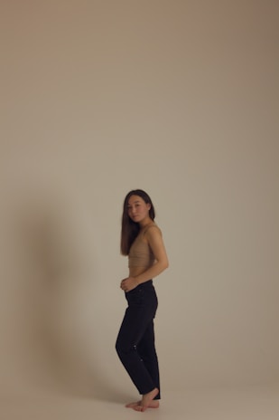 Model wearing a simple white tee and soft sweatpants, standing barefoot on warm desert sand.