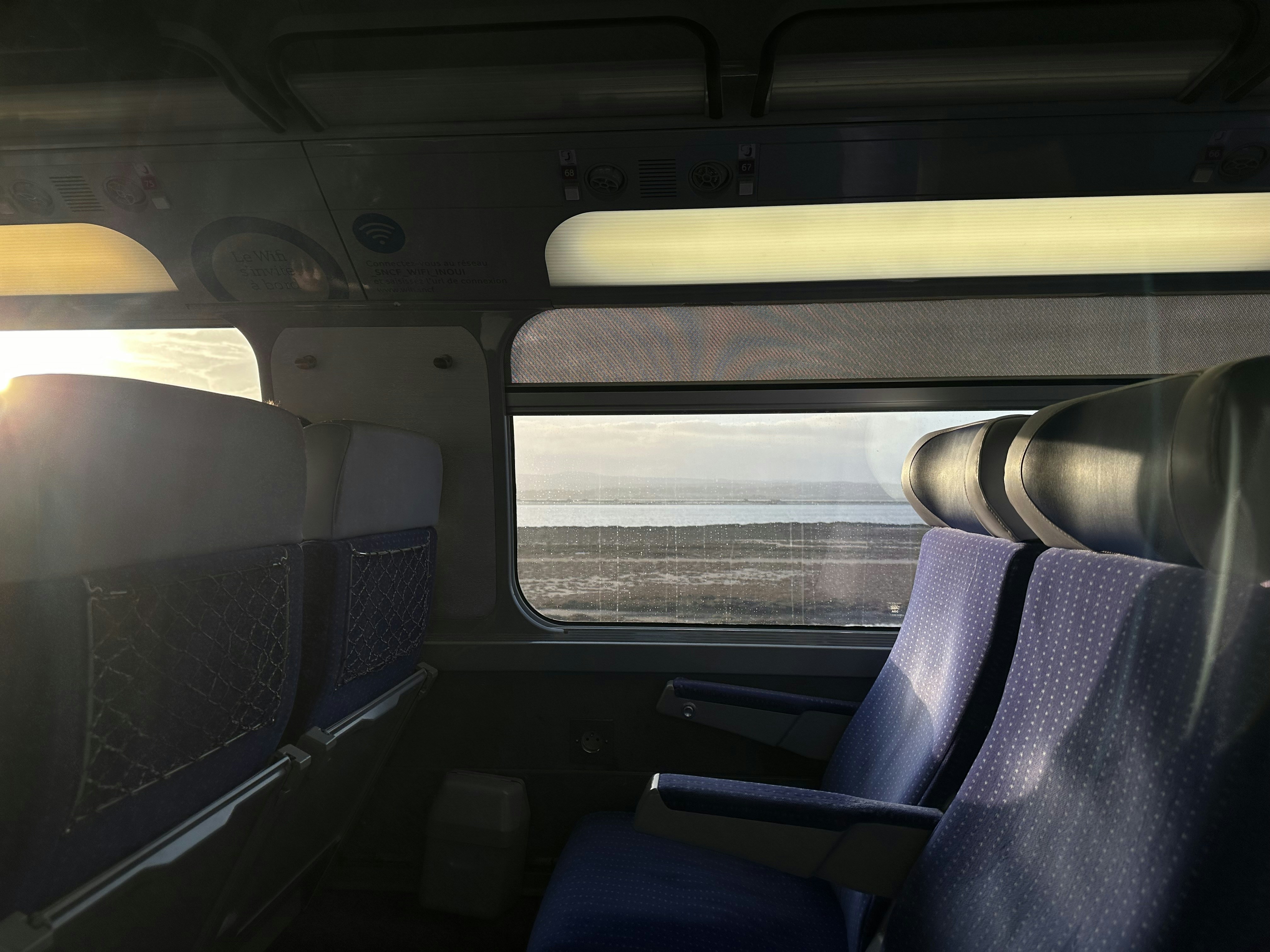 the inside of a train with a view of the ocean, Train