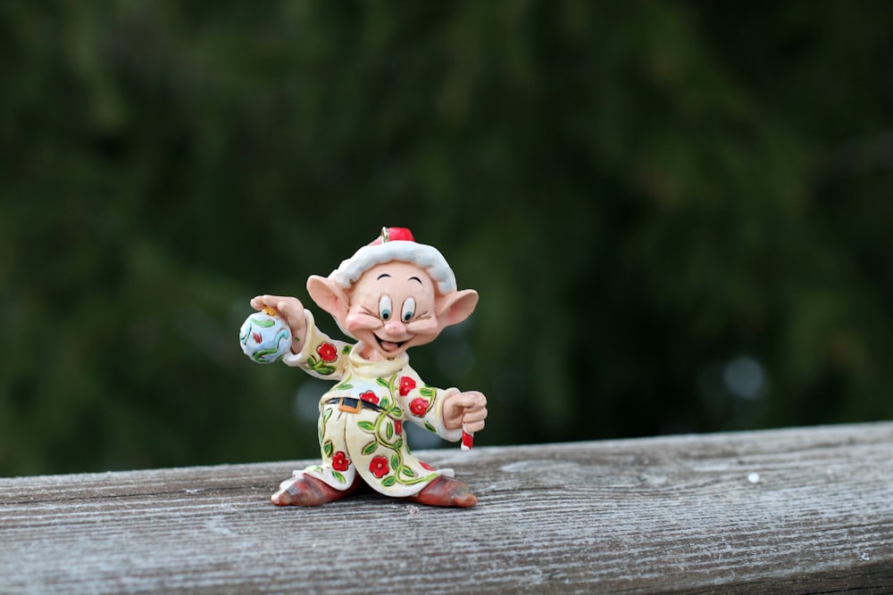 a small figurine of a troll on a wooden surface
