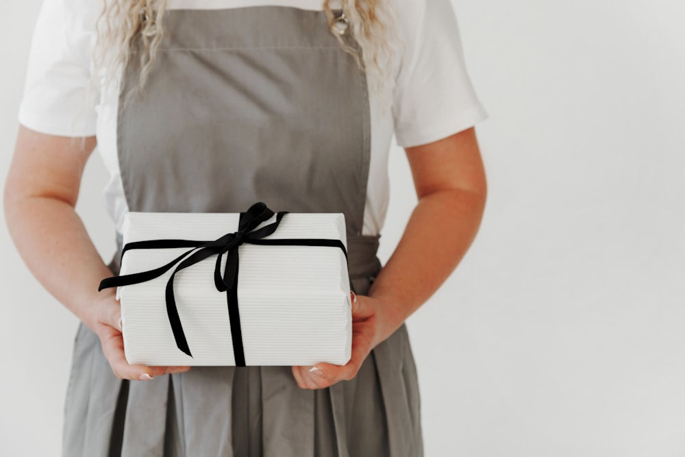 a woman in an apron holding a wrapped present